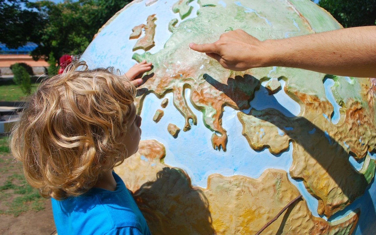 Niño señalando un globo terráqueo